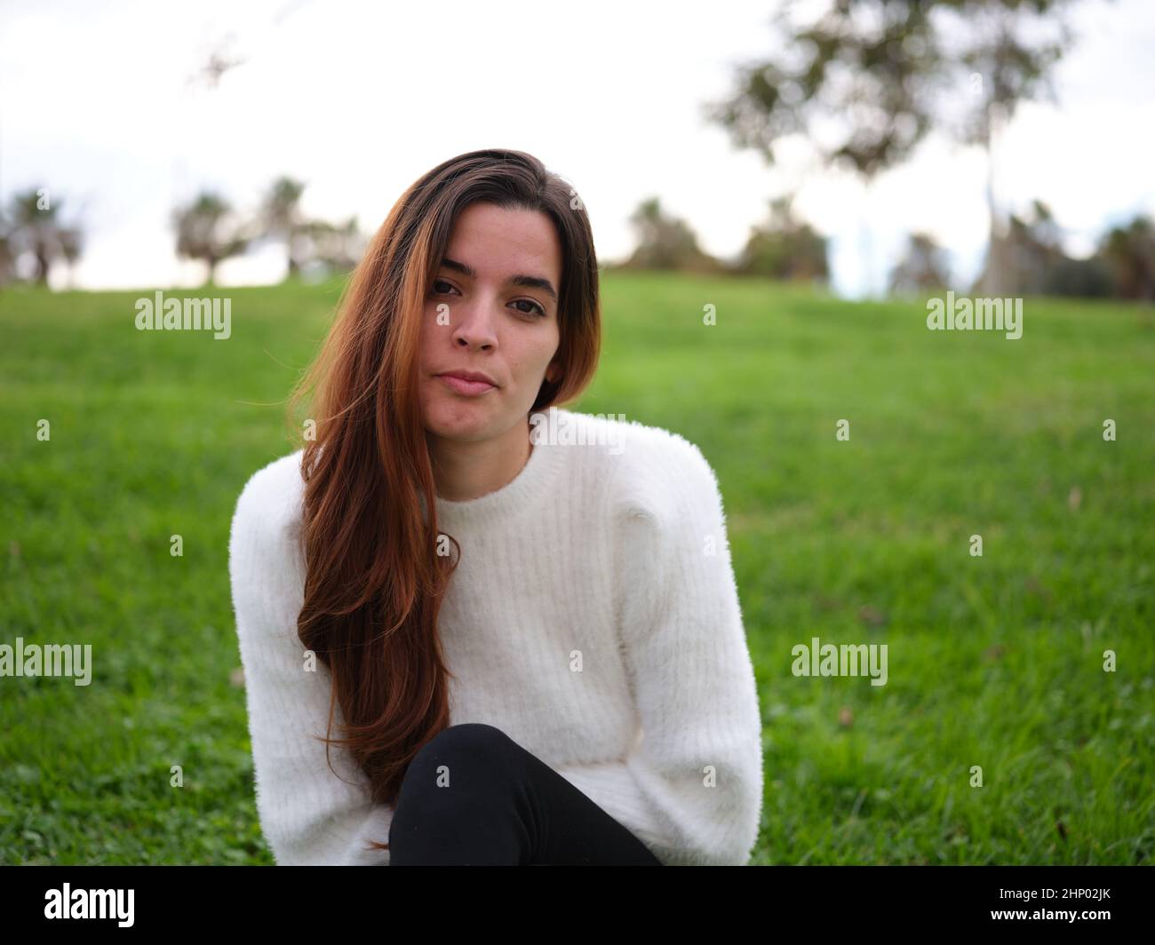 A scorned young woman in the park looking at the camera seriously Stock Photo