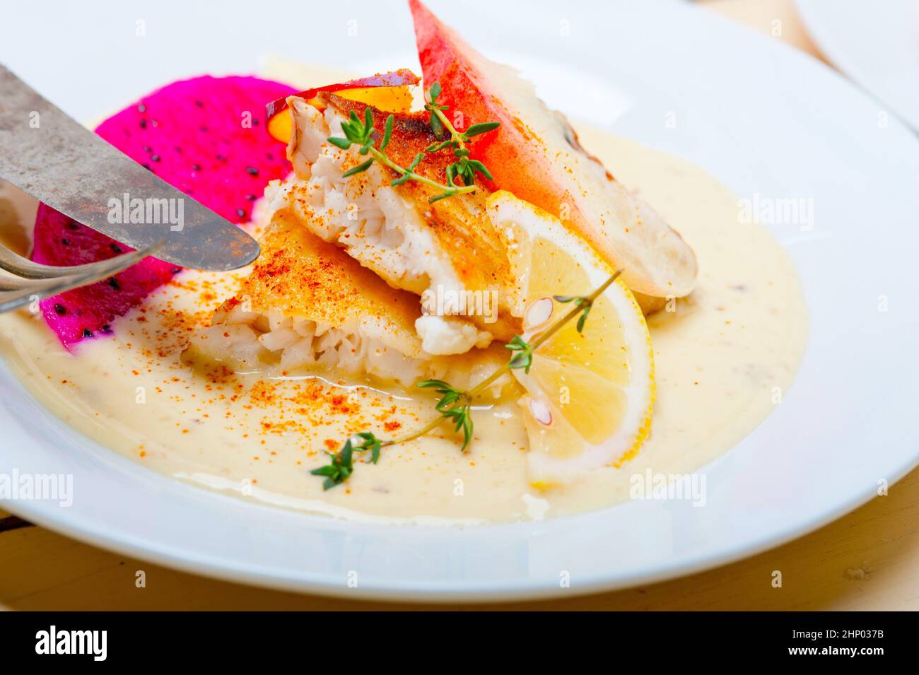 sea bream orata  fillet butter pan fried with fresh peach prune and dragonfruit slices thyme on top Stock Photo