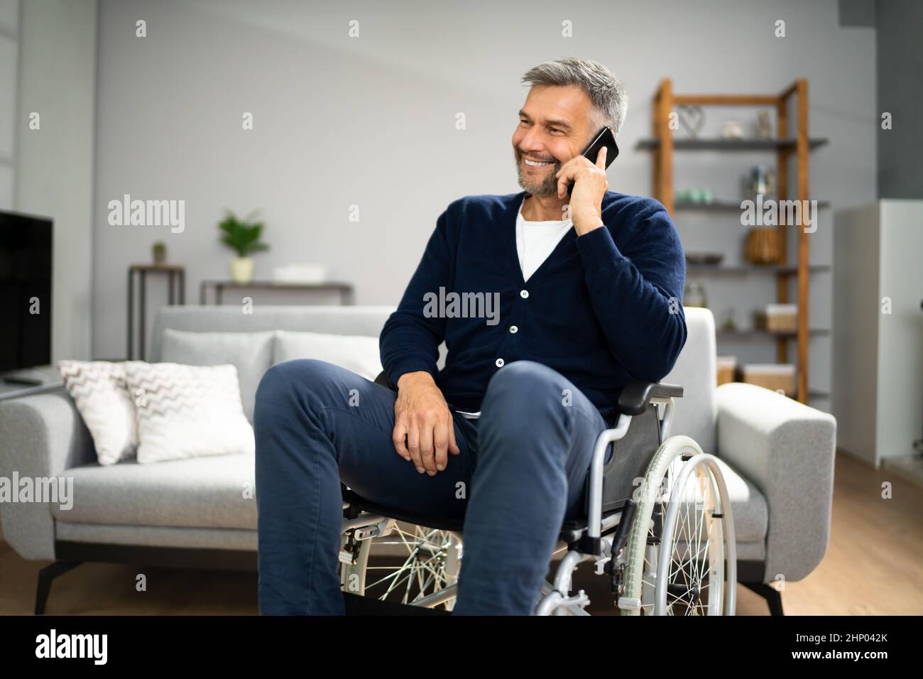 Older Man With Disability Using Smartphone Or Mobile Phone Stock Photo