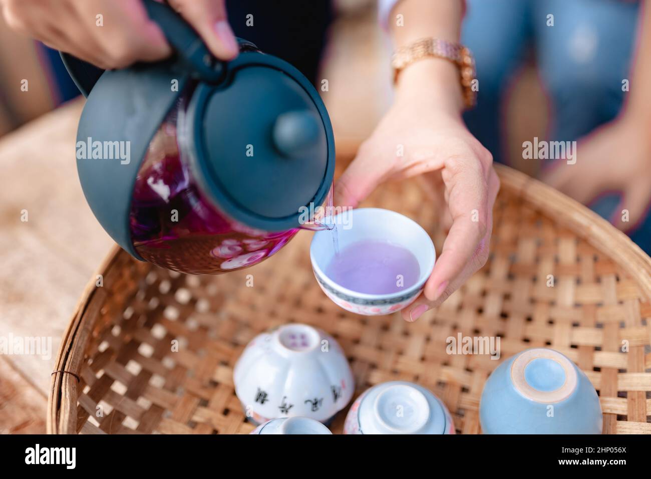 Teapot and tea cups on rattan at home. Stock Photo
