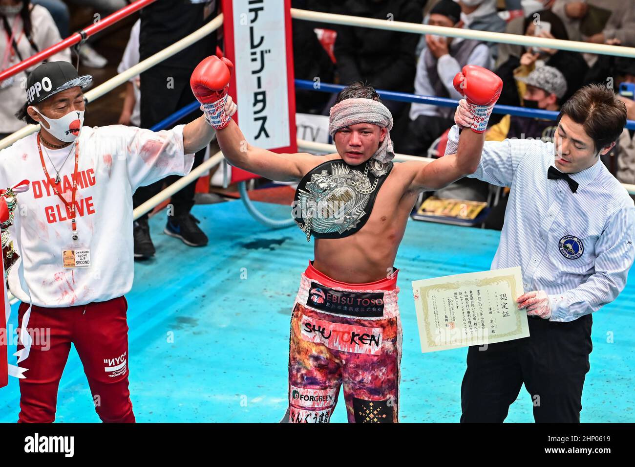Kyosuke Sawada, center, celebrates with trainer Takashi Yamada, left