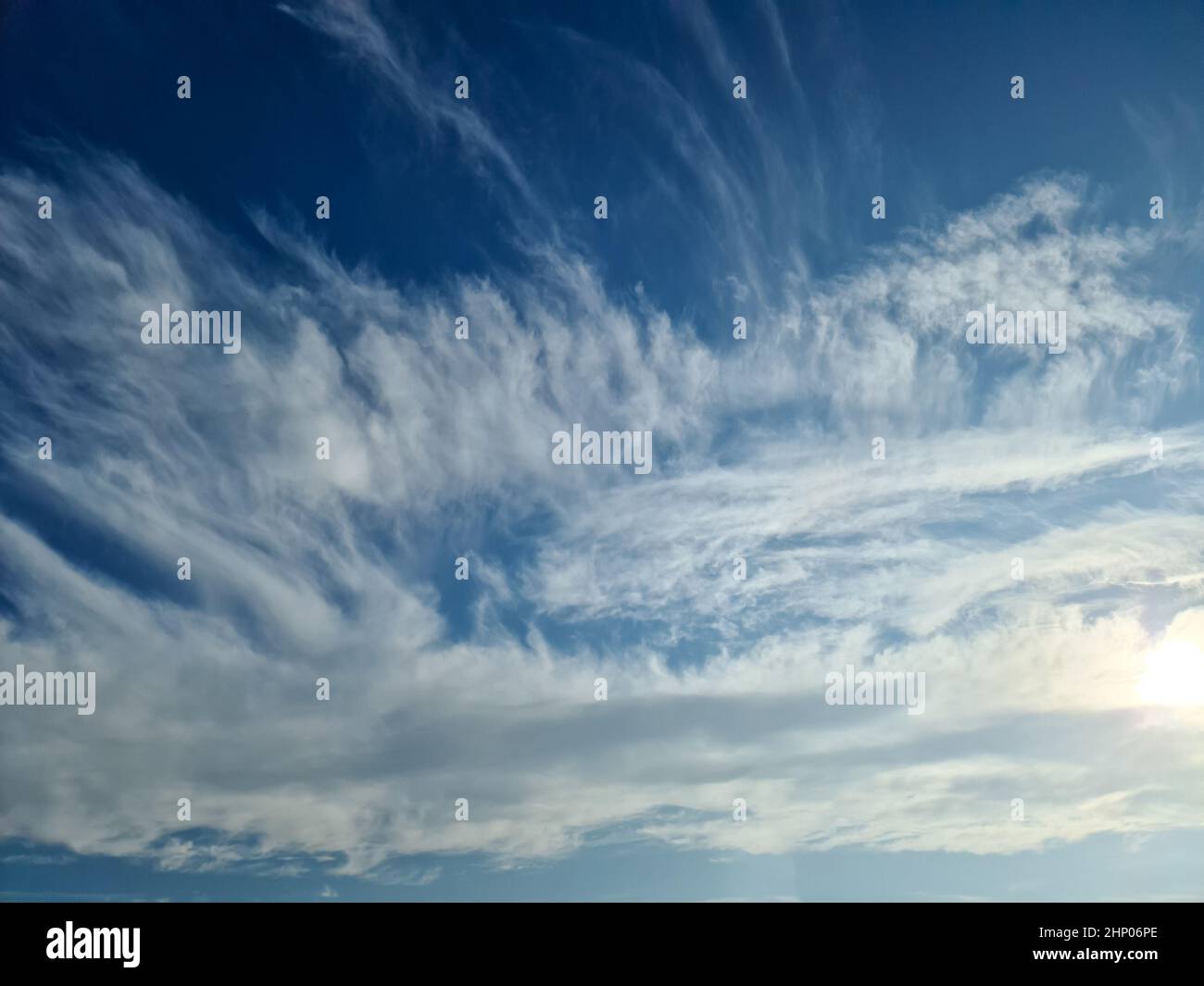 Stunning cirrus cloud formation panorama in a deep blue summer sky seen ...