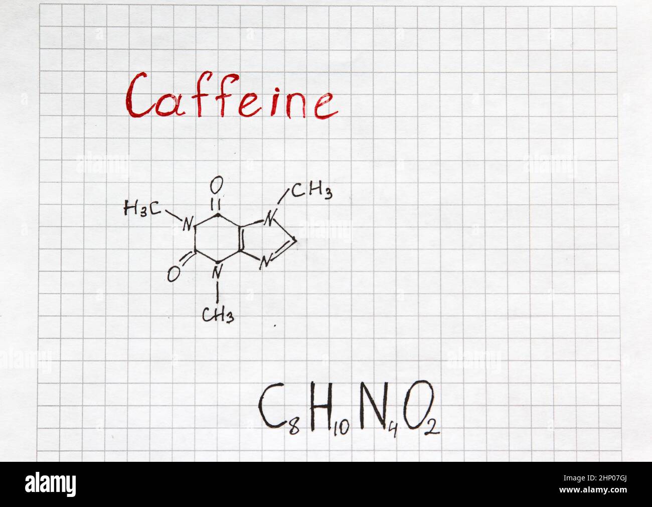 Chemical formula of Caffeine with some grains coffee. Close-up. Stock Photo