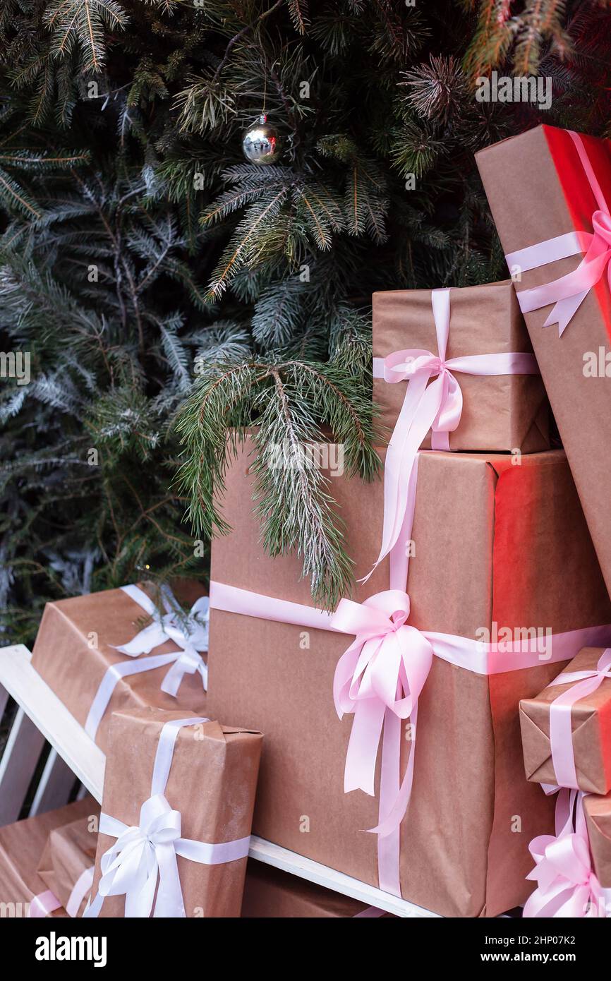 Craft gift boxes on the street near a wall made of a Christmas tree and