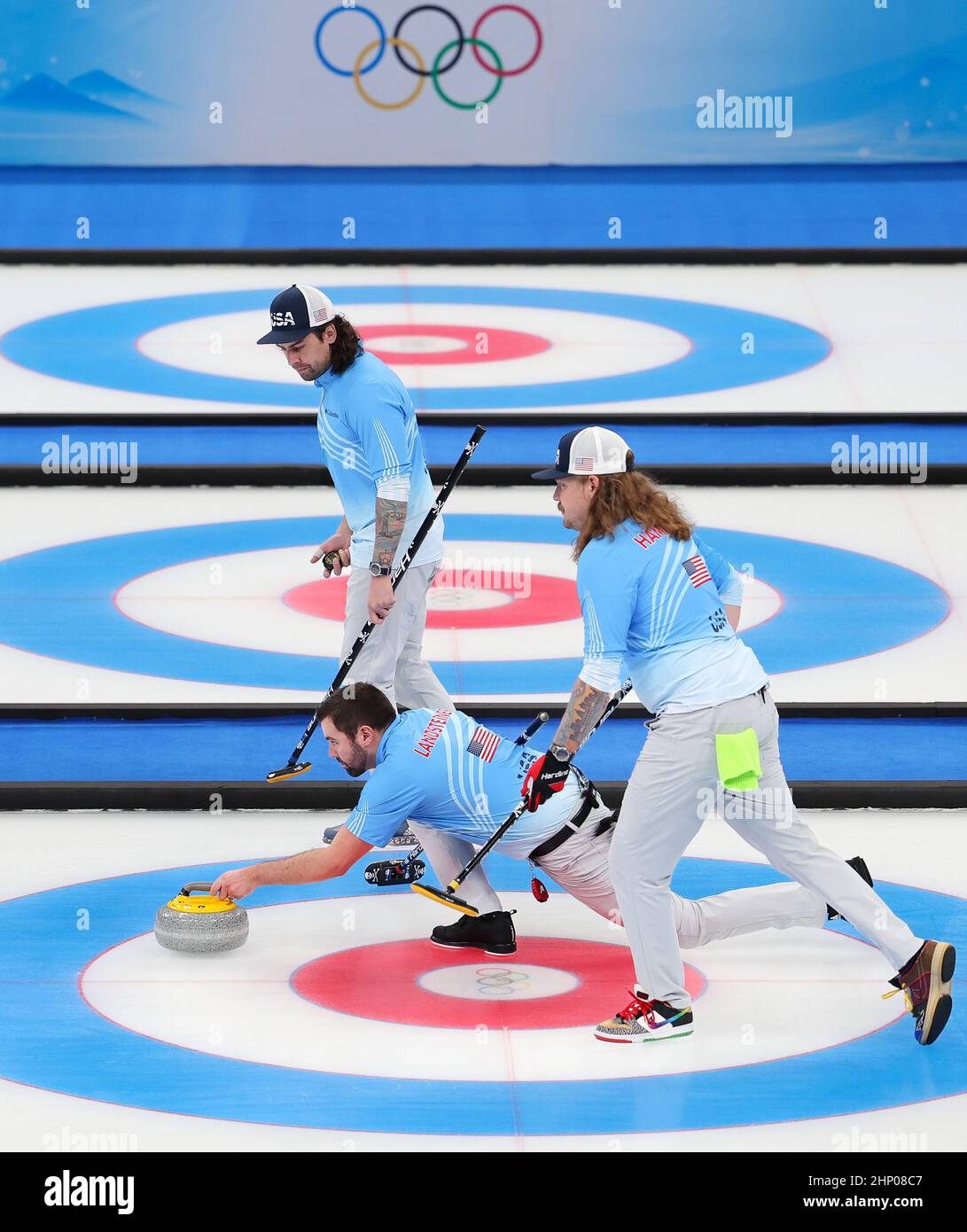 Beijing, China. 18th Feb, 2022. John Landsteiner (C) curls the stone during the curling men's bronze medal game of Beijing 2022 Winter Olympics between Canada and the United States at National Aquatics Centre in Beijing, capital of China, Feb. 18, 2022. Credit: Liu Xu/Xinhua/Alamy Live News Stock Photo