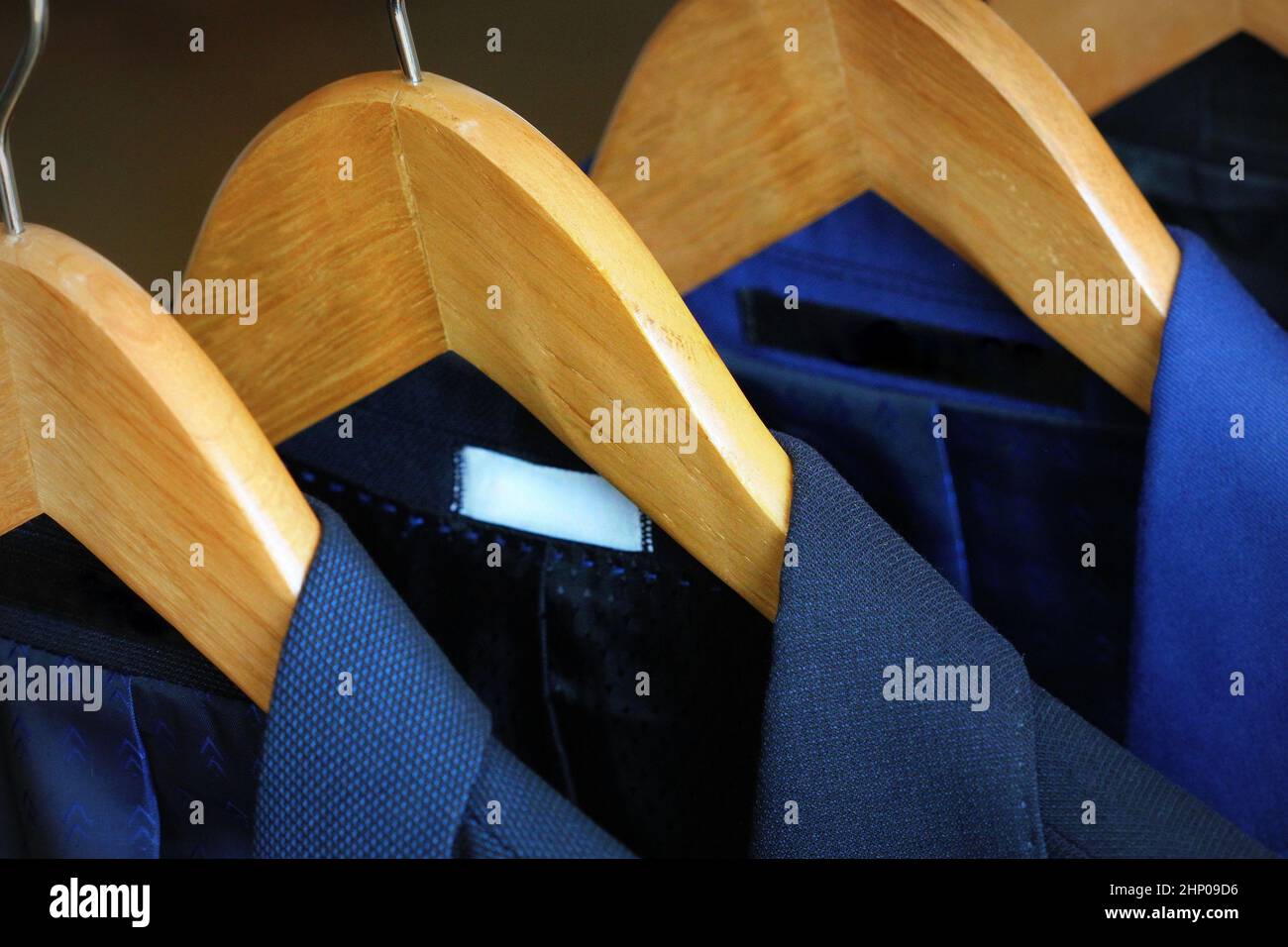 Row of men's suits hanging on rack for sale . Stock Photo