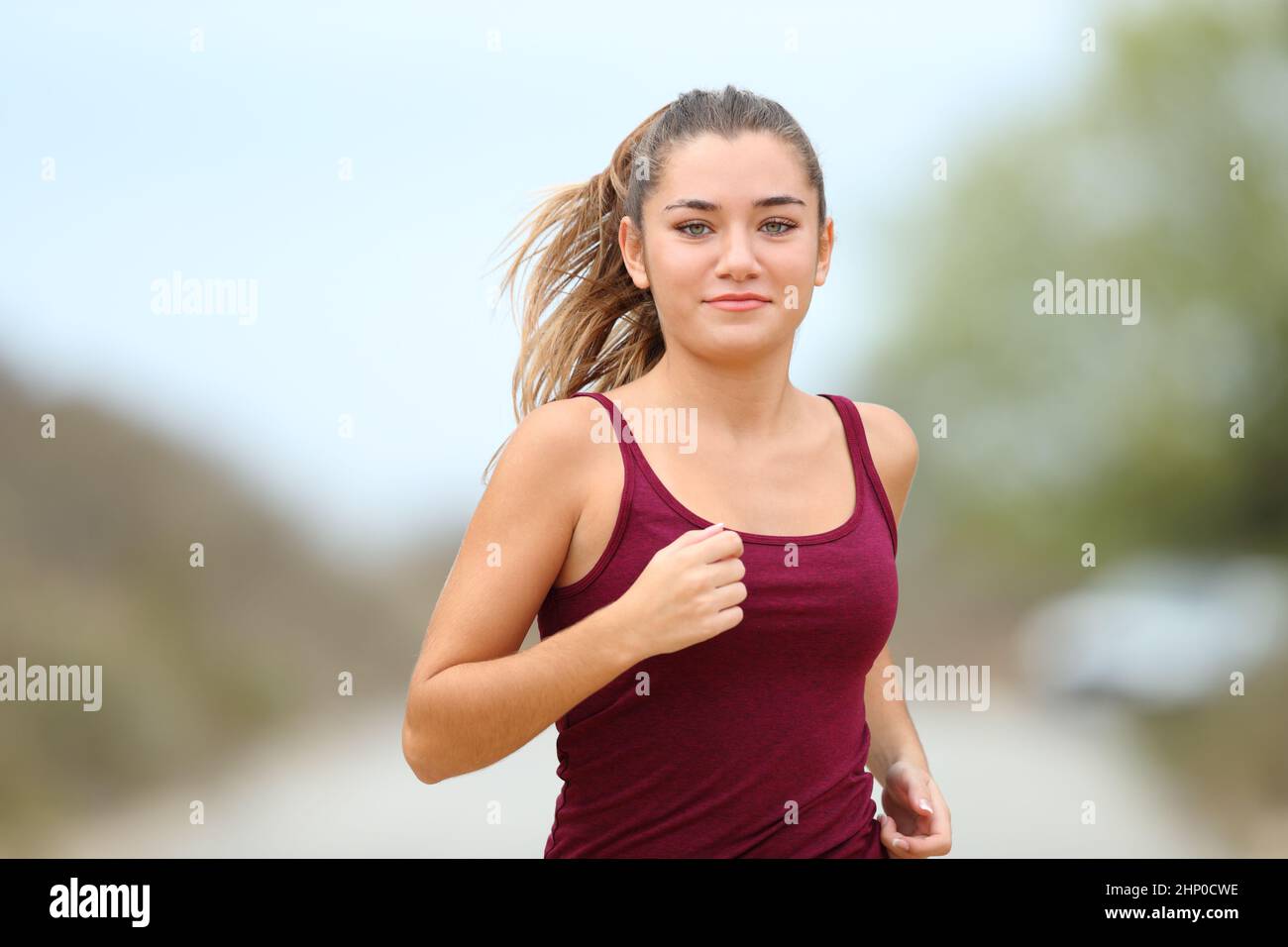 Running Portrait Front view portrait of a teenage runner running in the mountain Stock ...