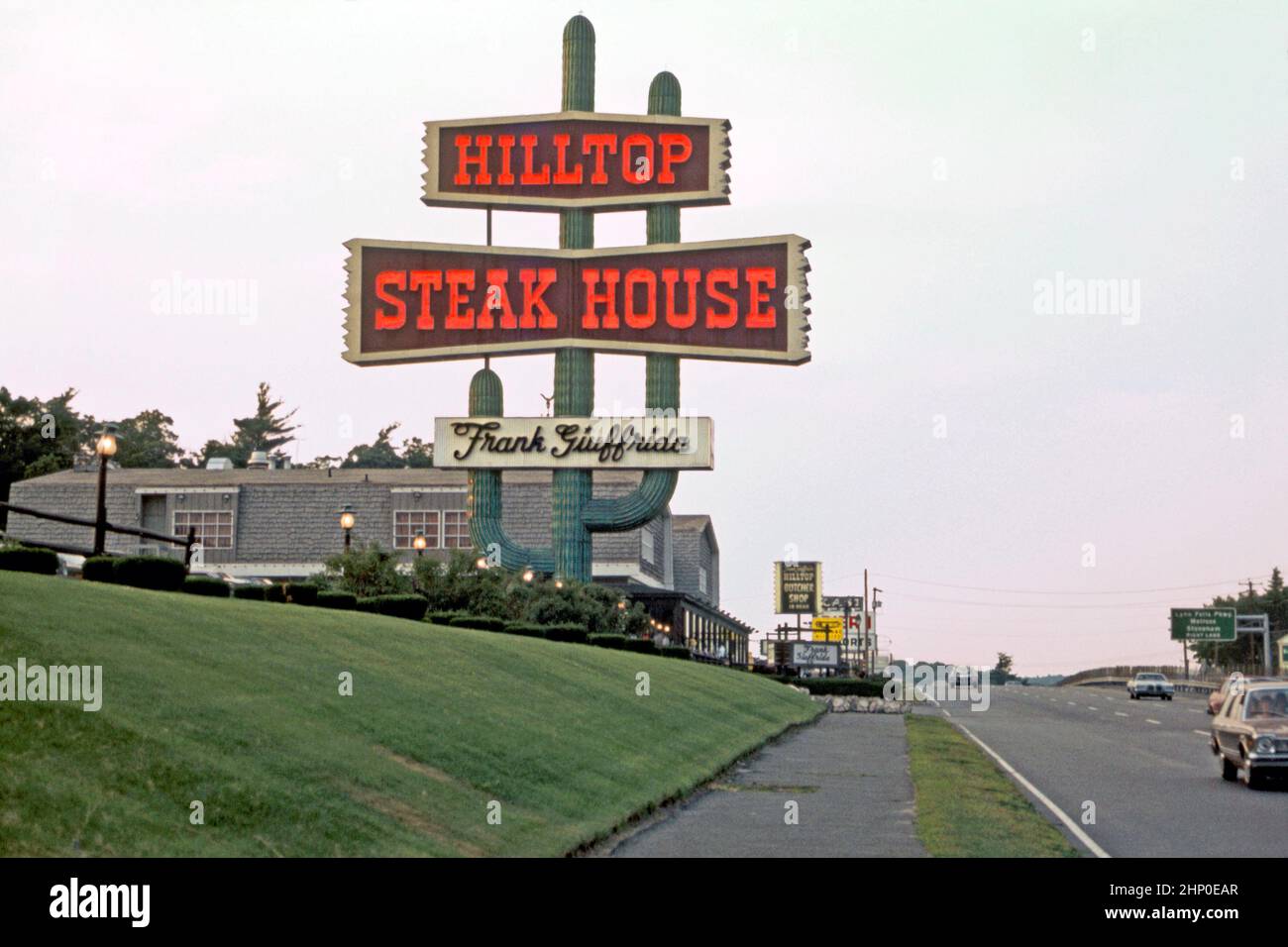 A 1982 view of The Hilltop Steak House restaurant – and its distinctive ‘cactus’ sign – on Route 1 in Saugus, near Boston, Massachusetts, USA. It was founded in 1961 by Frank Giuffrida, a butcher from Lawrence, Massachusetts. He converted a small bar on Route 1 into a 125-seat American steakhouse. The restaurant became popular – later the restaurant's capacity was 1,500 seats. The cactus sign was erected in 1966. It contained 210 fluorescent light bulbs and nearly half a mile of neon tubing. The restaurant closed in 2013 – a vintage 1980s photograph. Stock Photo
