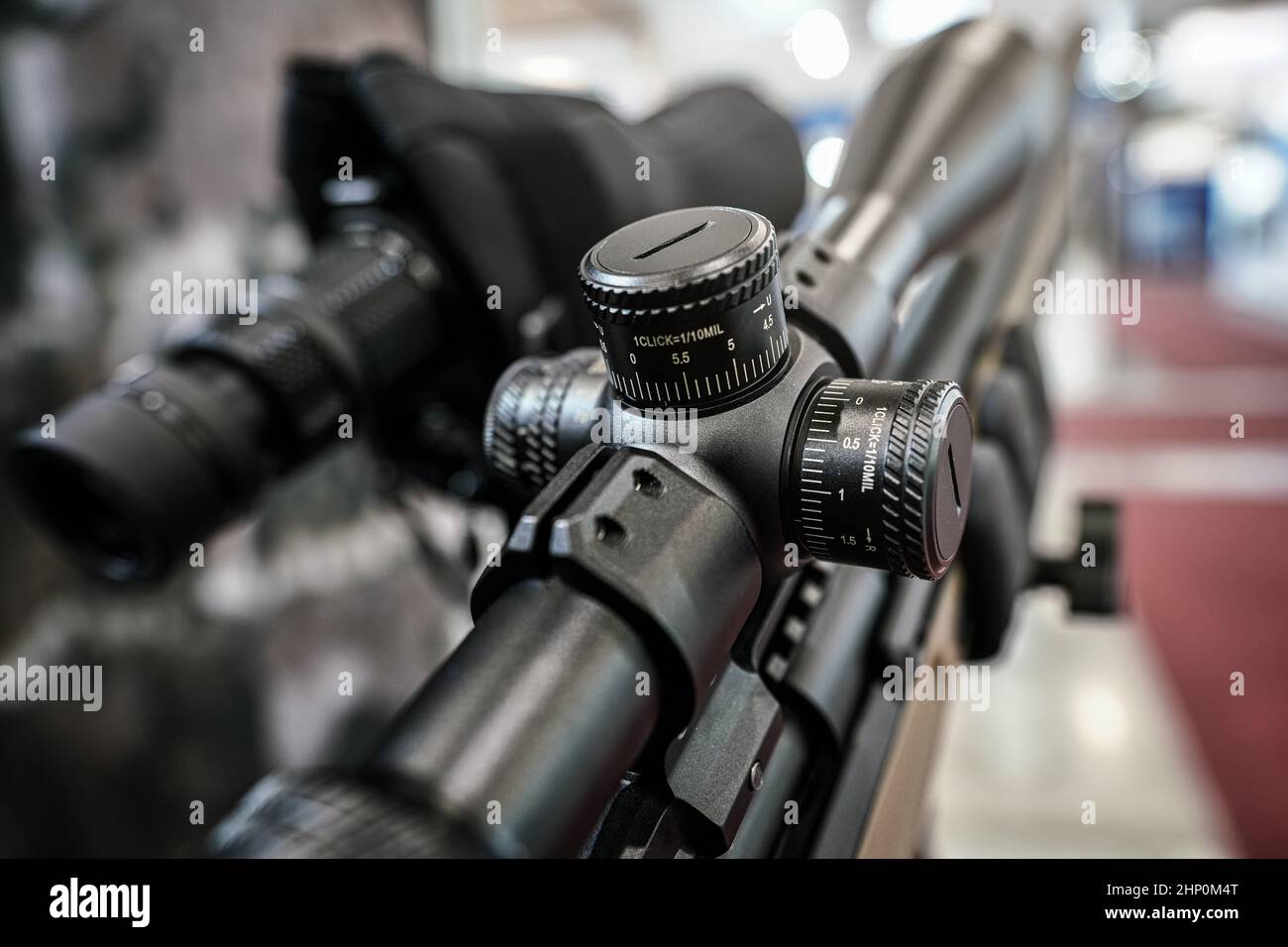 Black shooting scope optics mounted on rifle displayed at weapons
