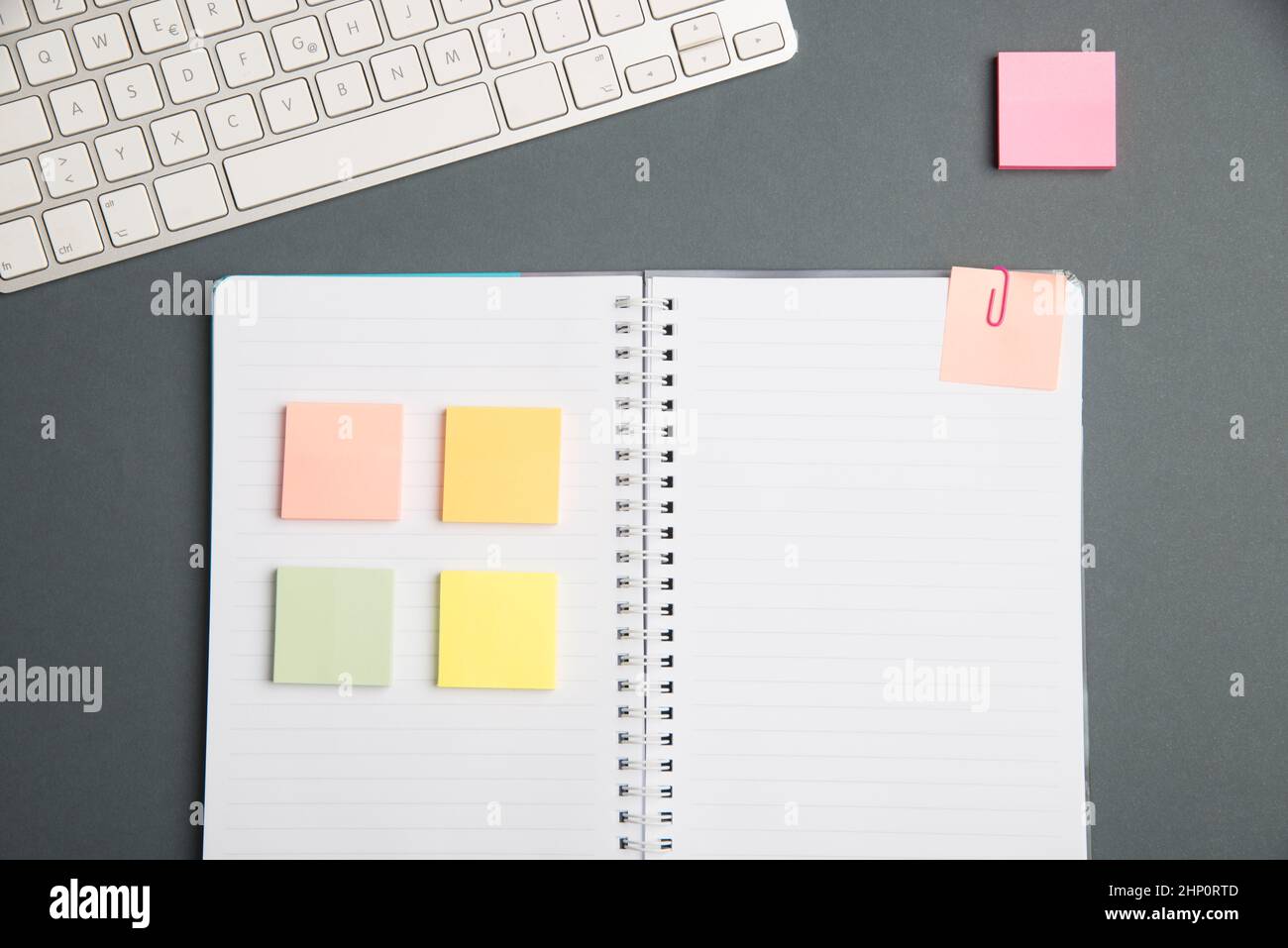 Keyboard Over A Table Beside A Notebook And Pens With Sticky Notes Stock Photo