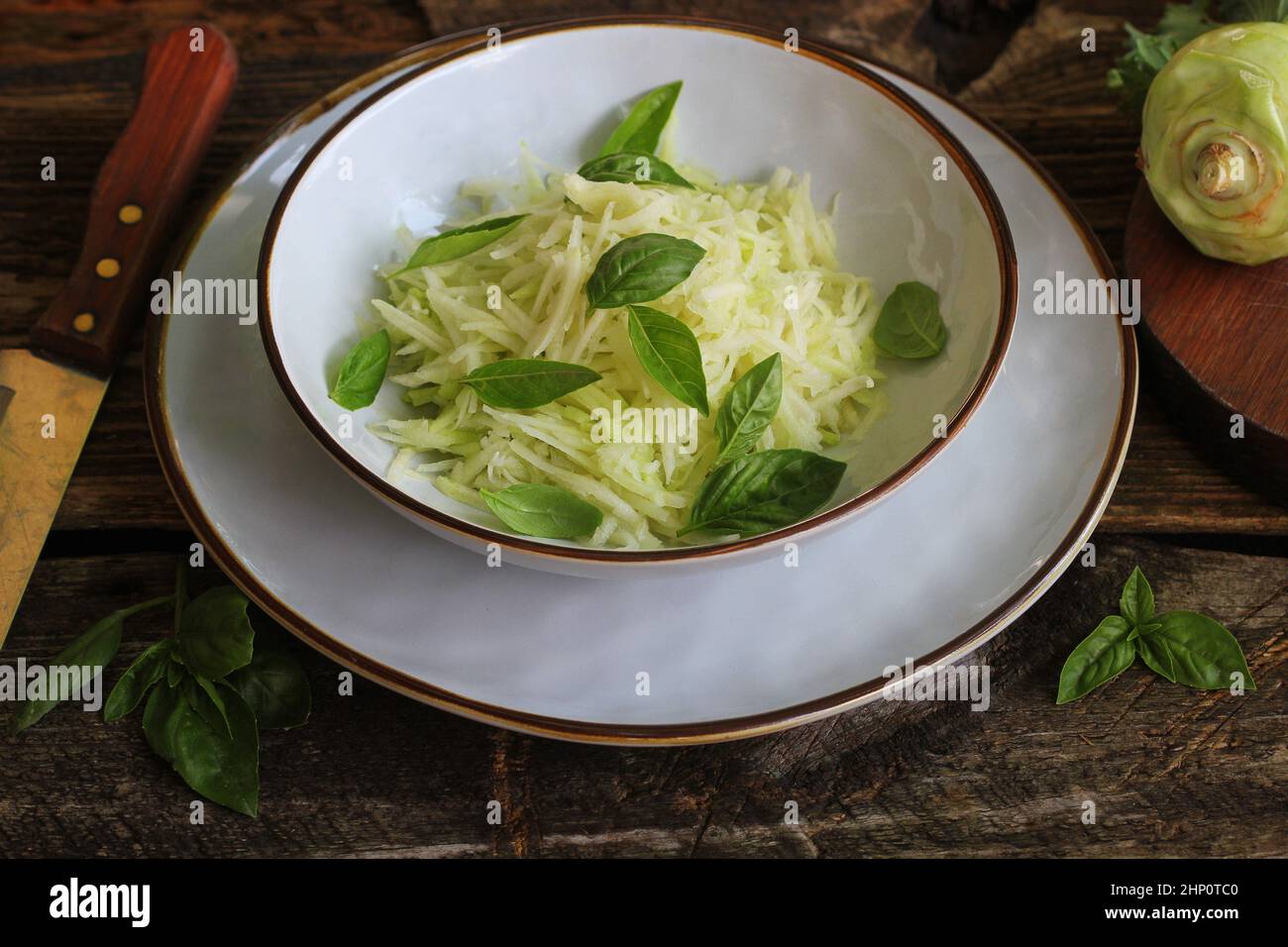 Fresh salad with kohlrabi, parmesan, basil and sesame dresing in a bowl. Vegetarian food . Stock Photo