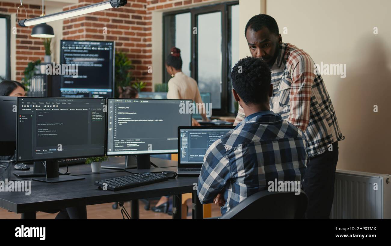 Software developer writing code on laptop and computer keyboard looking ...
