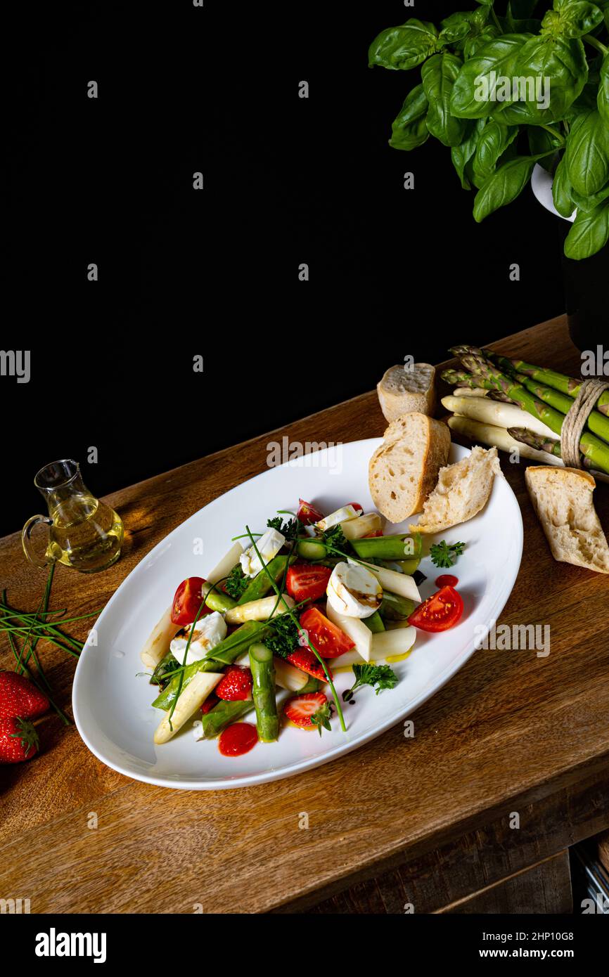 Asparagus salad with strawberries, tomatoes and goat cheese Stock Photo