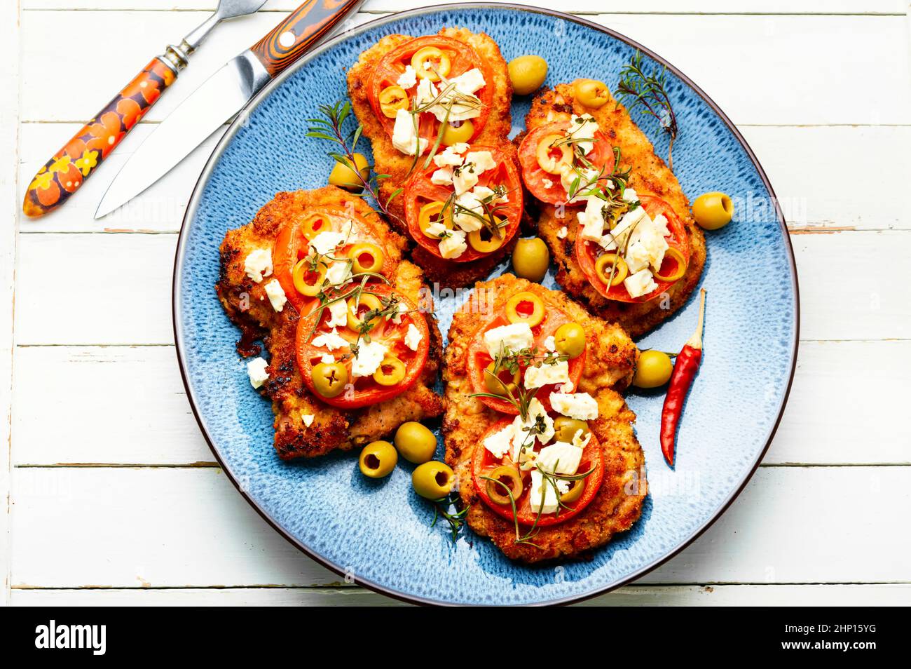 Thin layer of meat, breaded in breadcrumbs with cheese, olives and