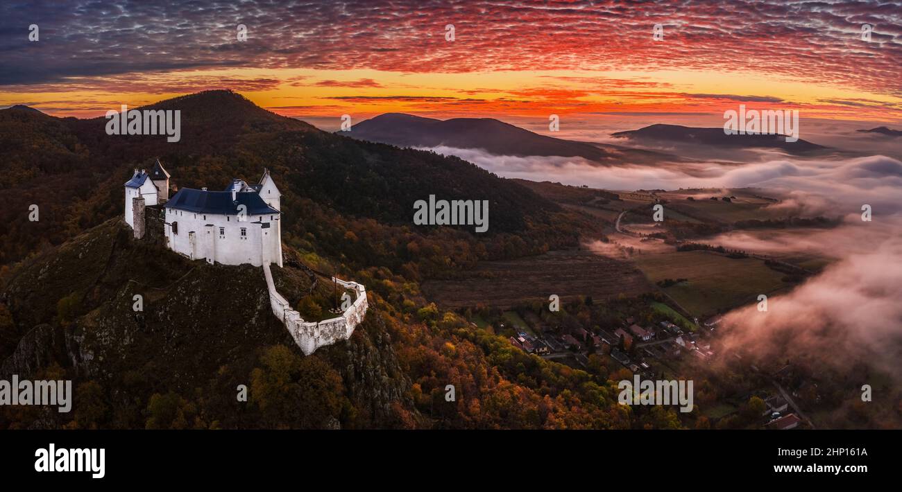 Fuzer, Hungary - Aerial panoramic view of the beautiful Castle of Fuzer (Fuzeri var) with amazing colorful foggy sunrise sky and clouds on an autumn m Stock Photo