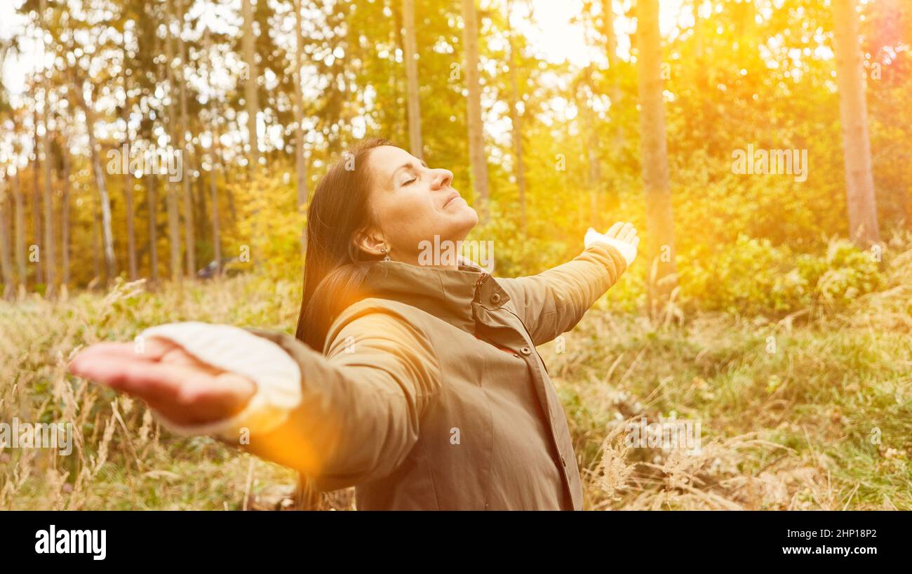 Relaxed woman standing breathing air in forest doing breathing exercise for mindfulness and relaxation Stock Photo