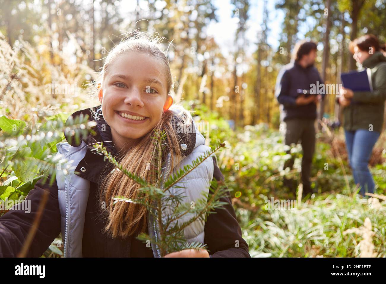 Happy girl with conifer for afforestation in the forest as environmental protection project Stock Photo