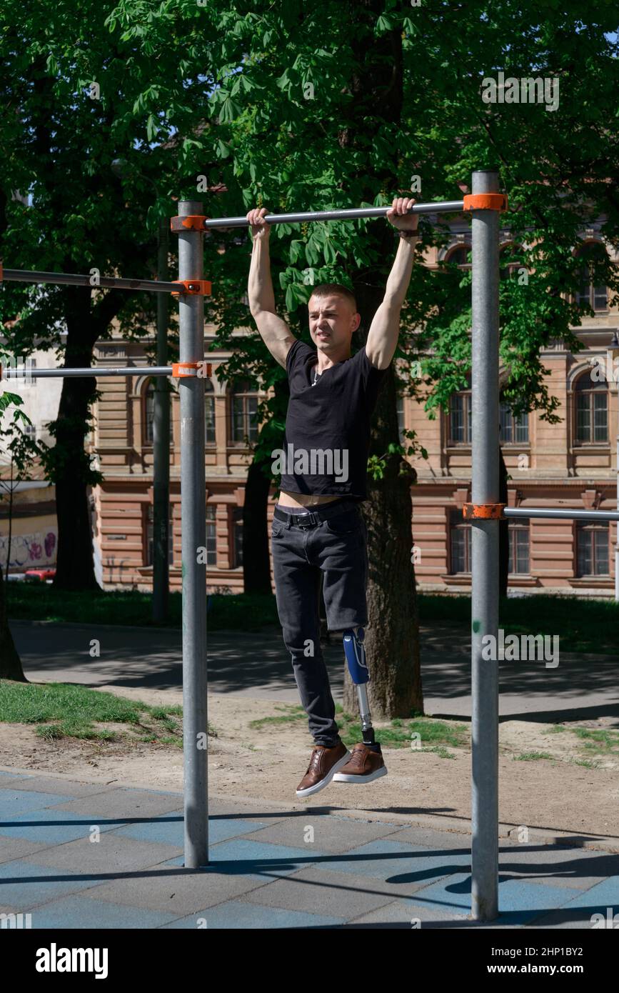athletic young man with artificial leg working out on a bars Stock Photo