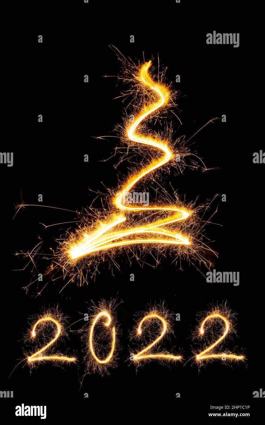 Merry christmas and happy new year 2022. Sparkling firework christmas and new year text on black background. Minimal abstract artistic style. Stock Photo