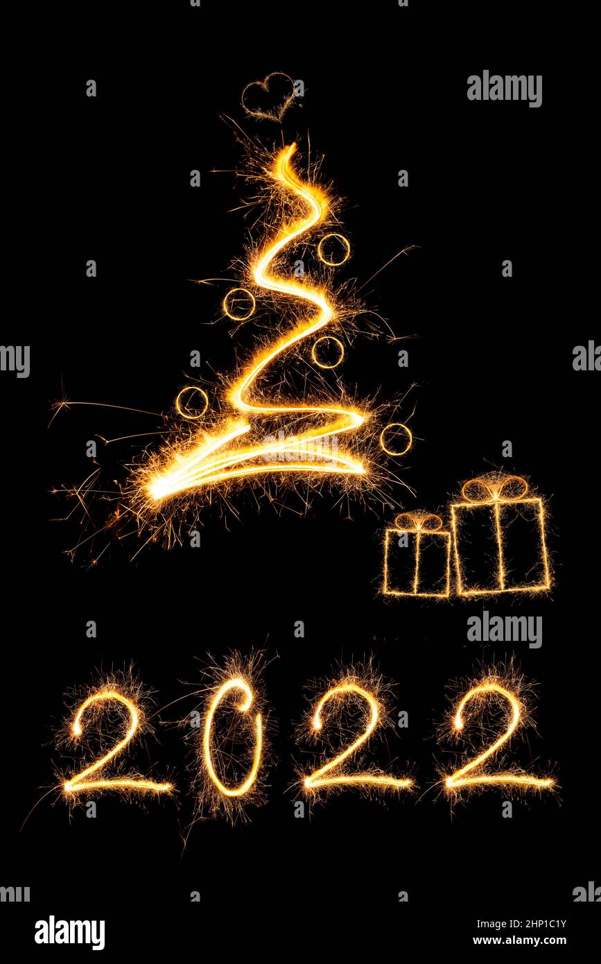 Merry christmas greeting card. Sparkling firework christmas tree with presents and number 2022. Stock Photo