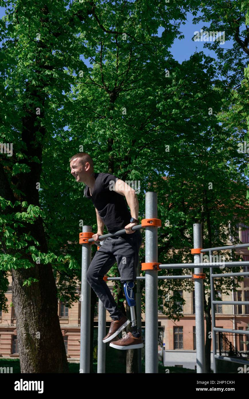 athletic young man with artificial leg working out on a bars Stock Photo