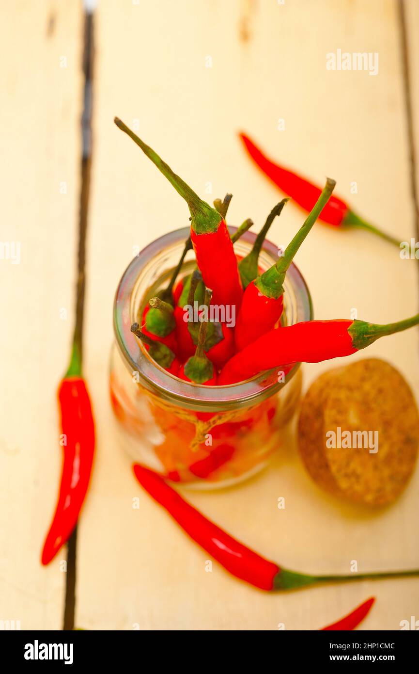 red chili peppers on a glass jar over white wood rustic table Stock ...