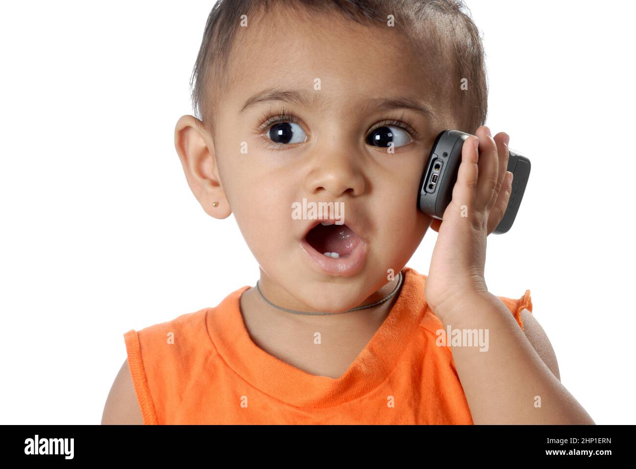 Mumbai India, Asia May 26, 2008 Asian indian Portrait of one year cute little baby girl talking on mobile phone on white background. Stock Photo