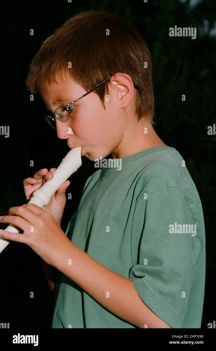 Young boy playing a recorder musical instrument Stock Photo Alamy
