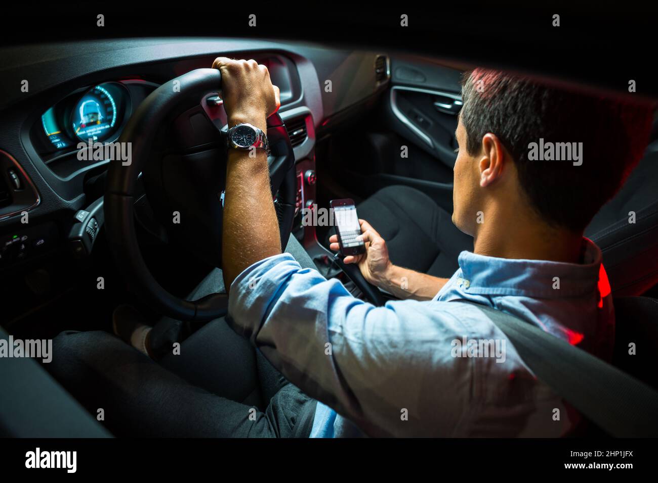 Driving a car at night - young man driving his modern car at night, in ...