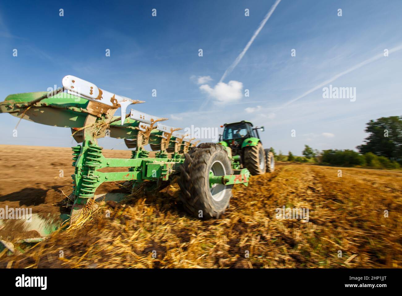 Tractor working on the farm, modern agricultural transport, farmer working in the field, tractor on a sunset background, cultivation of land, agricult Stock Photo