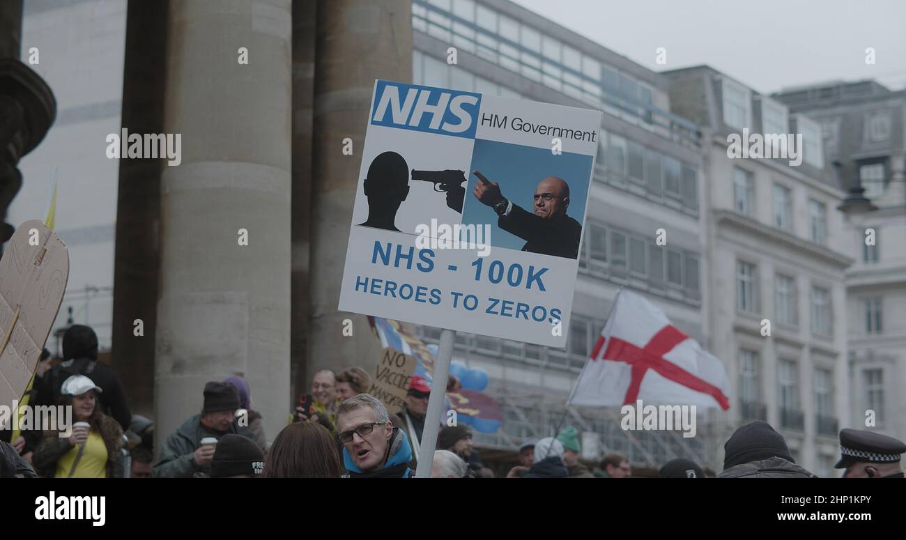 London, UK - 01 22 2022:  A protester holding a sign, ‘NHS - 100K, Heroes to Zeros’, outside Langham Place for the ‘World Wide Rally For Freedom’. Stock Photo