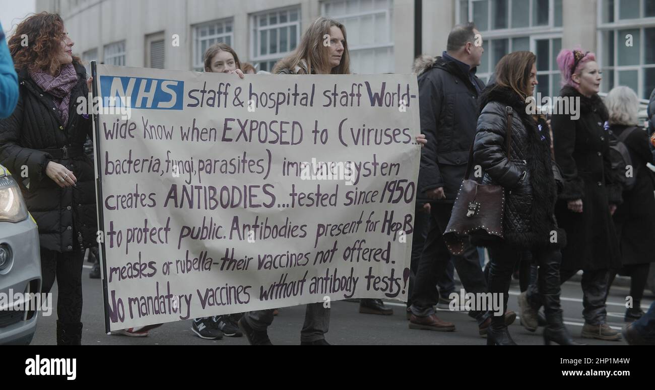 London, UK - 01 22 2022:  Female NHS workers holding a sign, marching with a crowd of protesters at Portland Place from Regent park. Stock Photo
