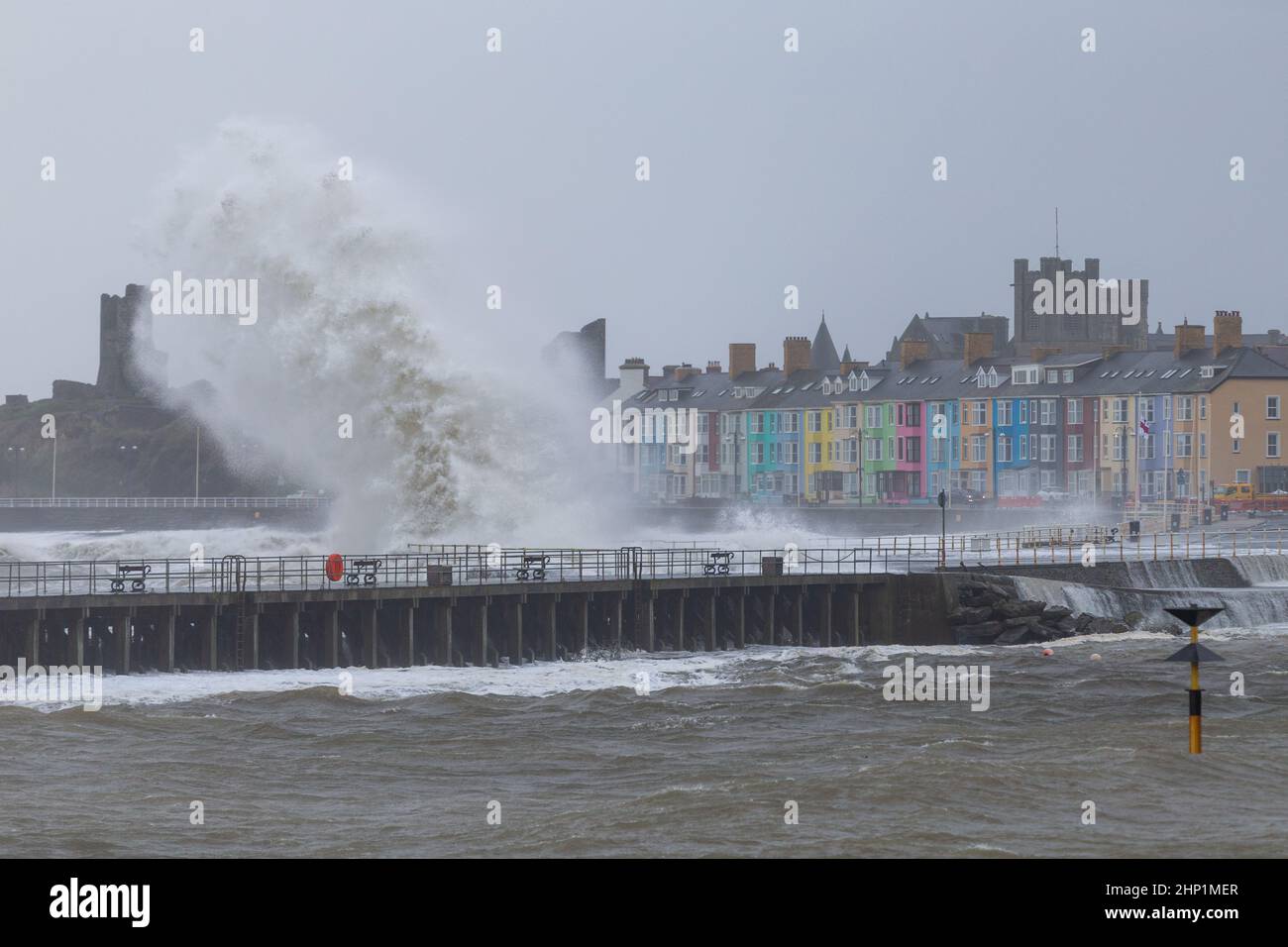 Aberystwyth, UK. 18th Feb, 2022. 18 February 2022, Aberystwyth, Wales, UK. Storm Eunice. Gale force winds cause very rough seas at high tide on the mid Wales coast. Huge waves pummel the the promenade and sea defences at the mouth of Aberystwyth harbour. Credit: atgof.co/Alamy Live News Stock Photo