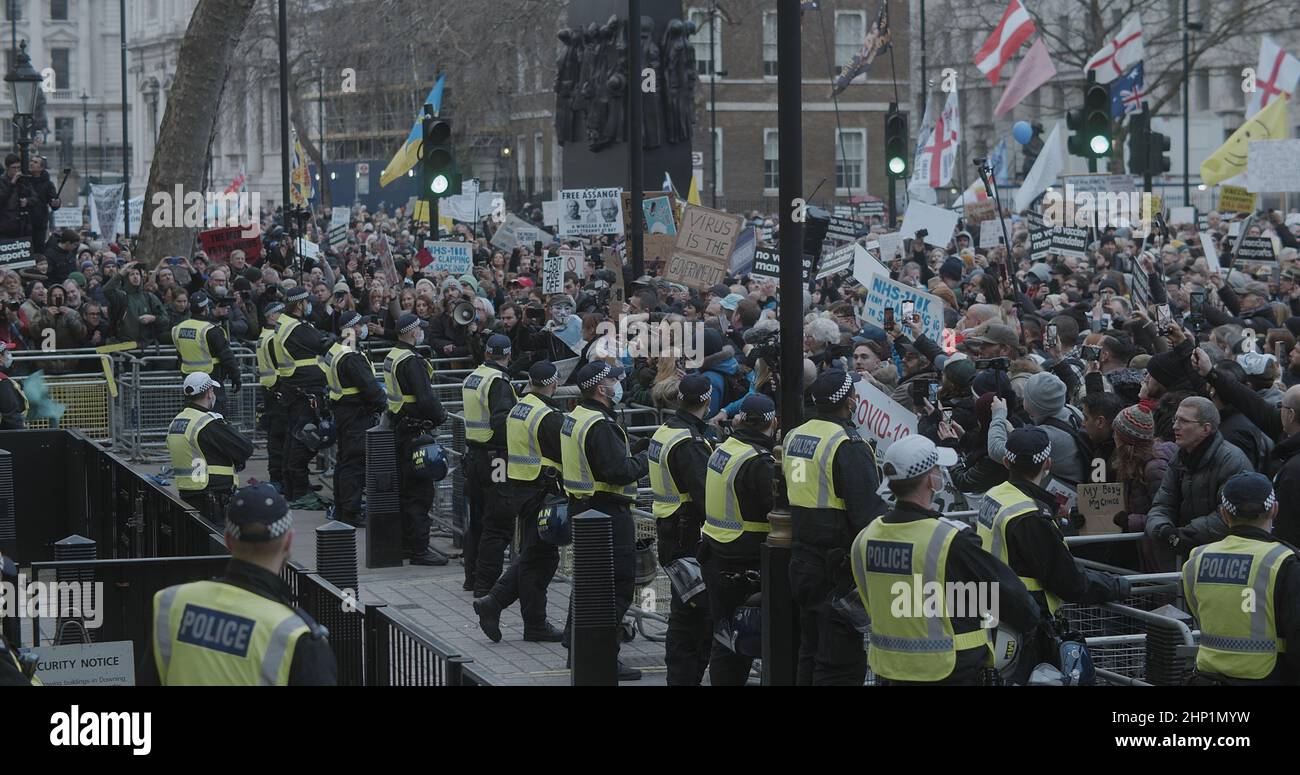 London, UK -01 22 2022: A crowd of protesters in support of NHS100K on Whitehall road outside Downing Street, guarded by police officers wearing masks. Stock Photo