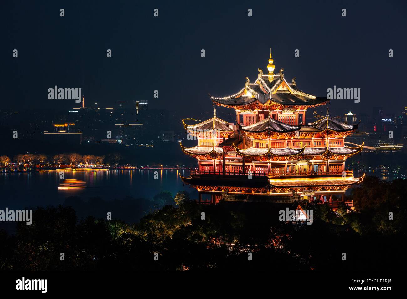 Night view of illuminated Cheng Huang Ge (City God Pavillion) with West Lake and city skyline on background, Hangzhou, China Stock Photo