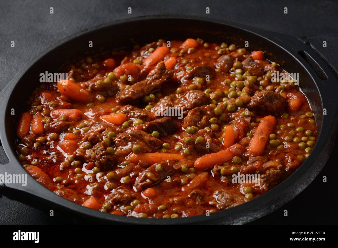 Beef stew, meat ragout with carrots, onions and green peas. Meat stew