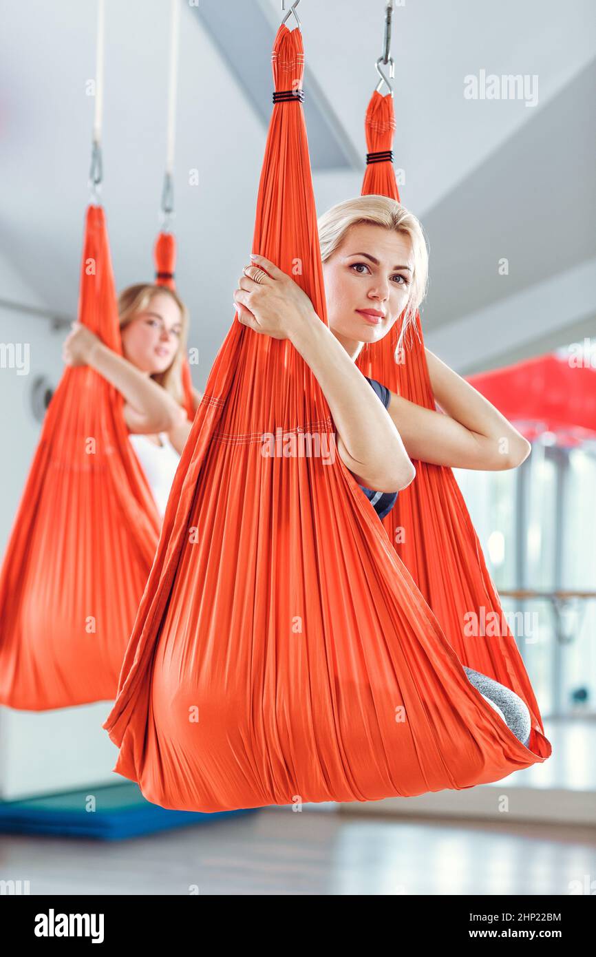 Fly yoga. two women practices antigravity yoga with a hammock Stock