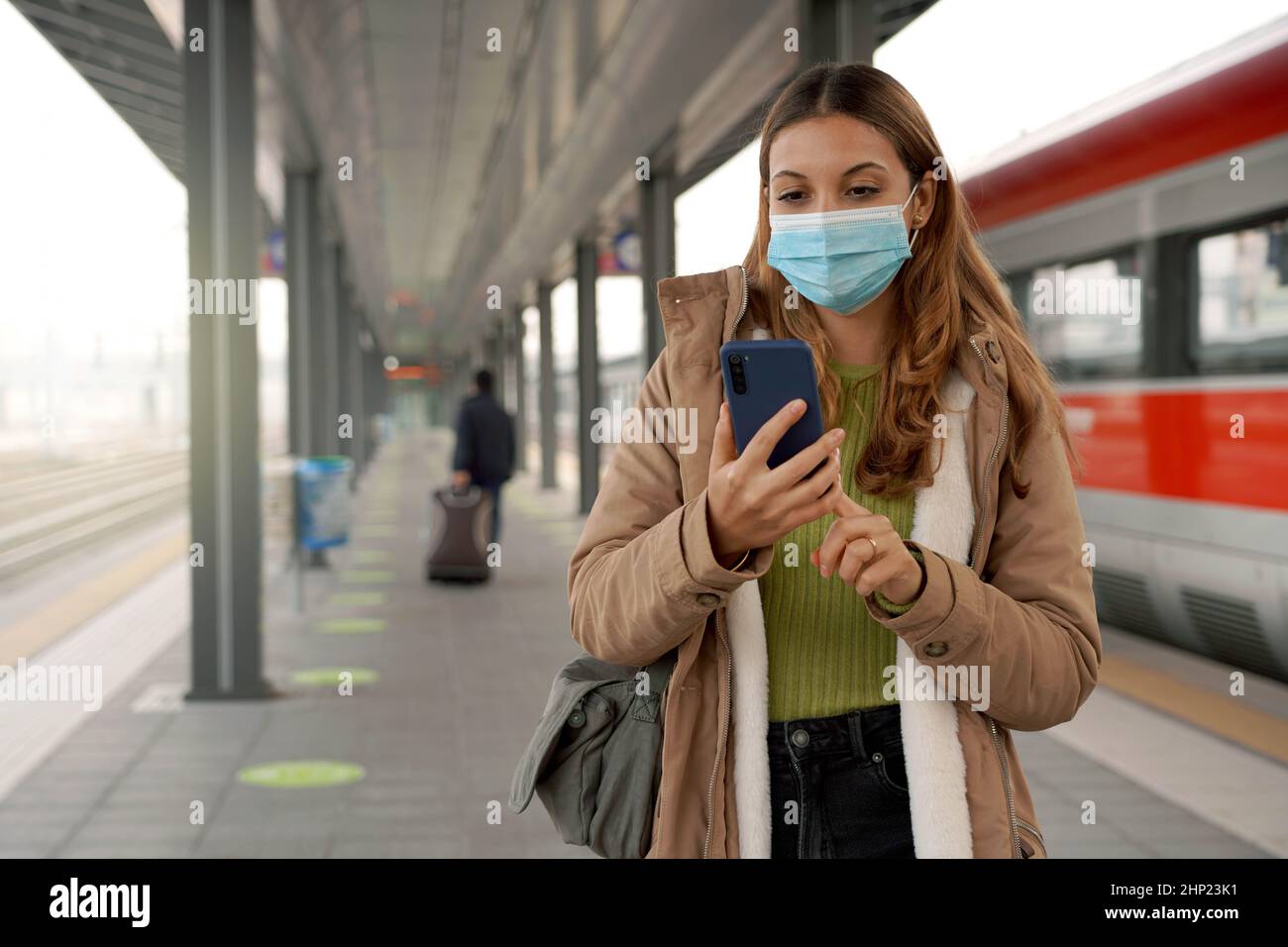 Traveler woman wearing surgical mask at train station buying ticket ...