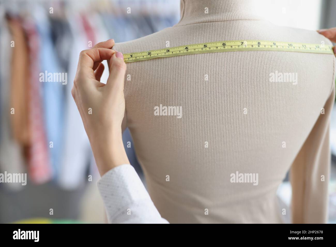 Seamstress with measuring tape measures on a mannequin Stock Photo Alamy