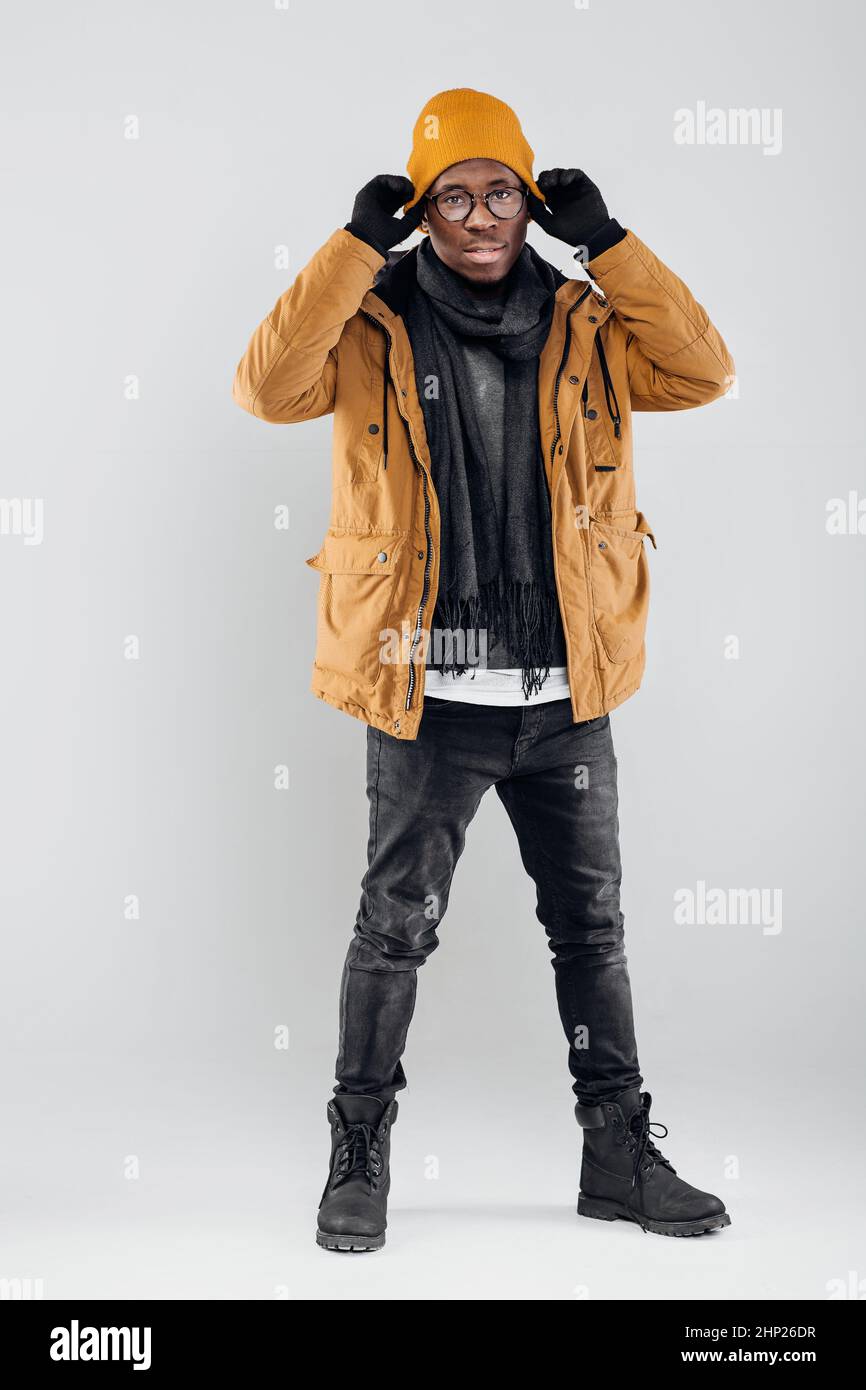 young smiling AfricanAmerican man in yellow hat and jacket posing