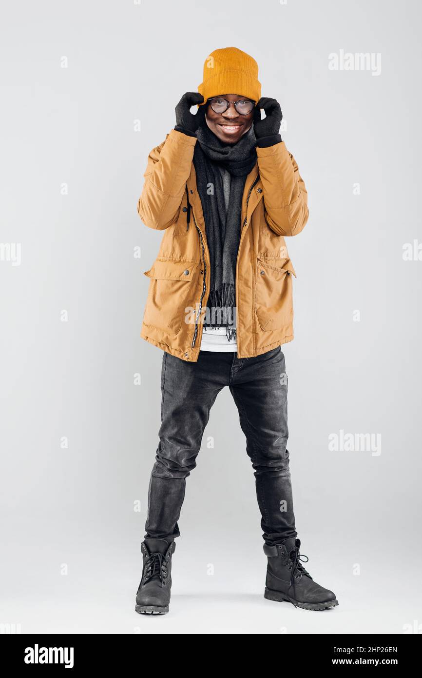 young smiling AfricanAmerican man in yellow hat and jacket posing