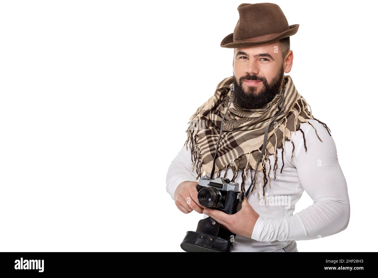 young male photographer with retro camera takes photos on white background Stock Photo