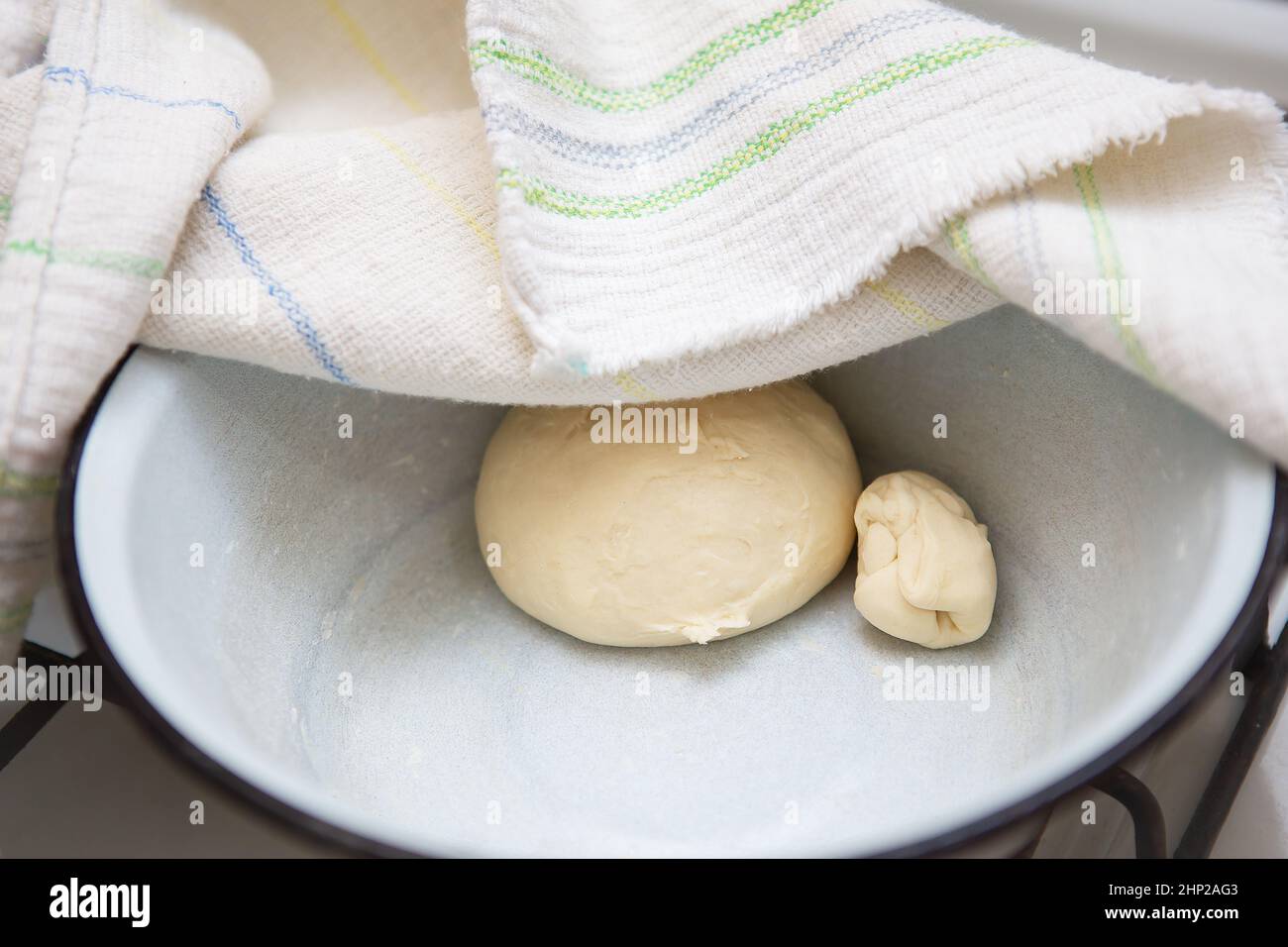 Preparation of dough for making dumplings, ravioli, manti, dumplings. Dough in a plate under a towel Stock Photo