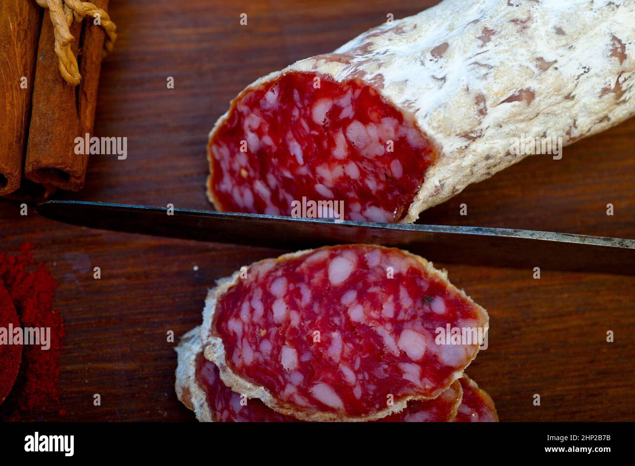 traditional Italian salame cured sausage sliced on a wood board Stock Photo