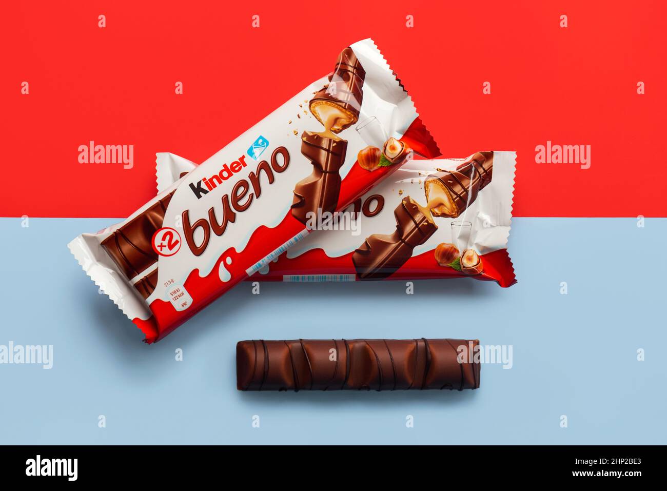 Closeup of packages of Kinder bueno and Kinder Bueno milk chocolate bar over red and blue background Stock Photo
