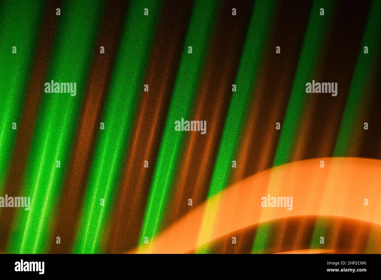 Green corrugated metal background with orange light trail. St Patrick's day abstract backdrop. Stock Photo