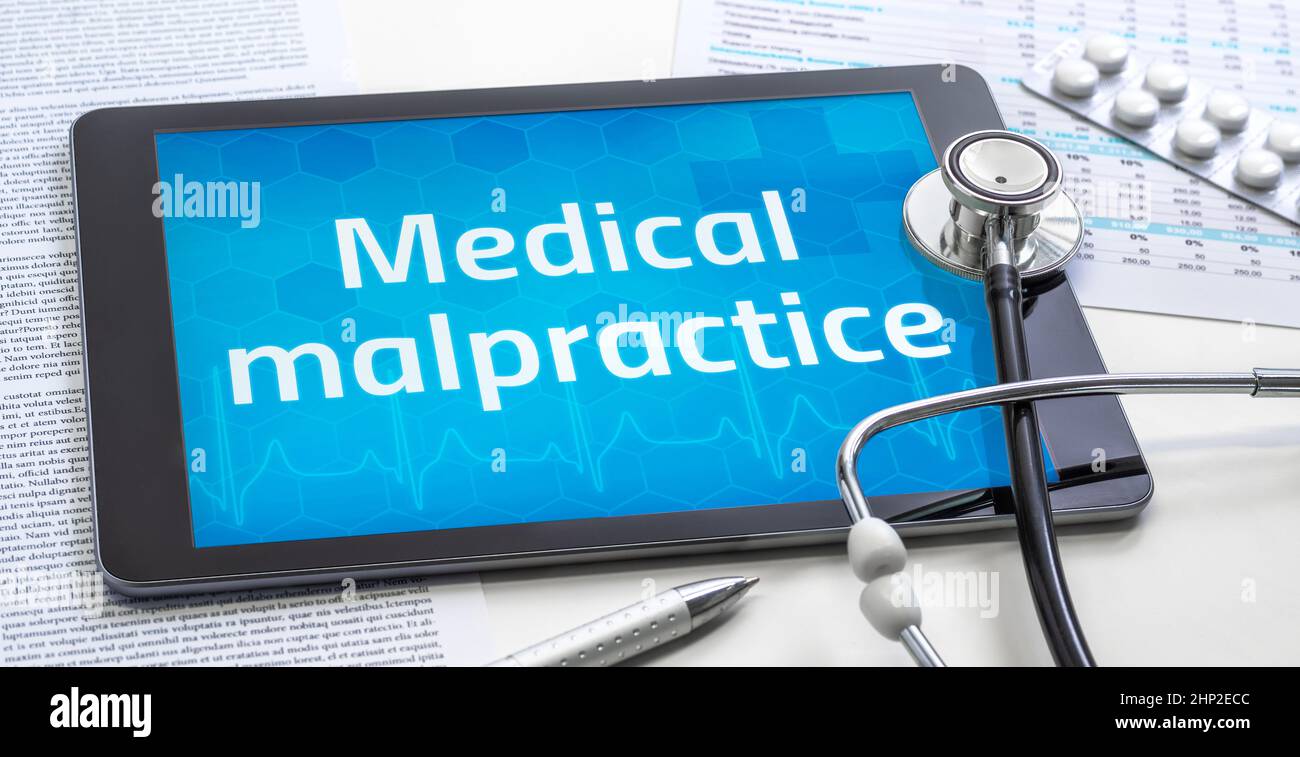 The word Medical malpractice on the display of a tablet Stock Photo