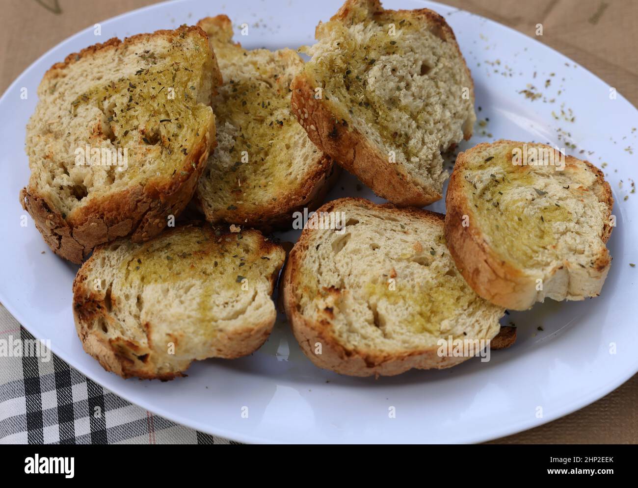 baguette slices with garlic and olive oil on a white plate Stock Photo
