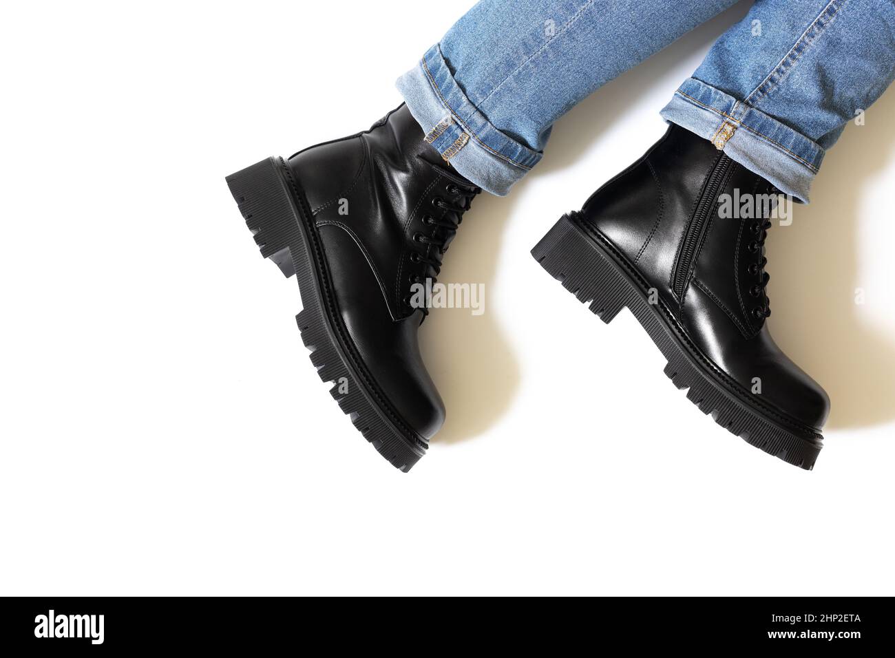 Black unisex boots isolated on white background for winter and autumn  weather with round toe, block heel and embossed hard sole worn on someone  feet Stock Photo - Alamy