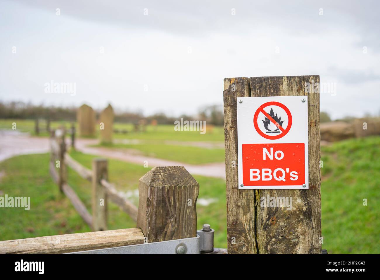 Close up of No BBQs sign isolated on a wooden fence post, outdoors in a UK country park. Stock Photo